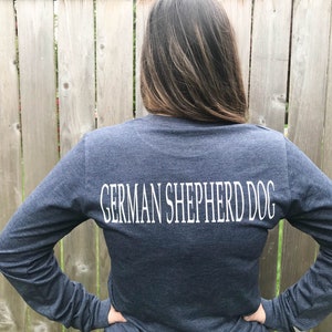 K&ouml;nnte beinhalten: Ein marineblaues Langarmshirt mit dem Aufdruck "GERMAN SHEPHERD DOG" in Wei&szlig; auf der R&uuml;ckseite.