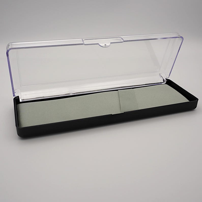 May include: A black plastic case with a clear plastic lid. The case has a gray felt lining.