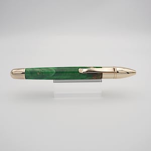 May include: A green and gold pen with a wood grain pattern. The pen has a gold clip and a gold tip.