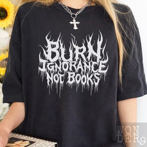 May include: Black t-shirt with a white graphic that reads "Burn Ignorance Not Books" in a metal font.