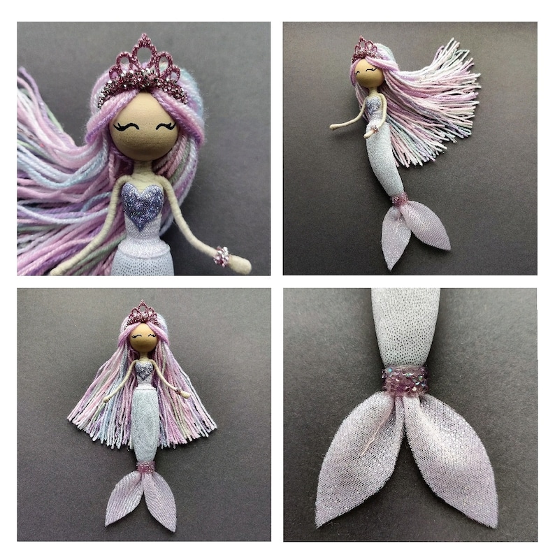 May include: A handmade doll with a pink and white yarn wig, a purple bodice, and a white and silver glitter mermaid tail. The doll is wearing a pink crown.