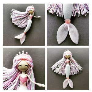 May include: A handmade mermaid doll with a pink and white yarn hair, a pink bodice, and a white tulle tail. The doll is wearing a crown and has a painted face.