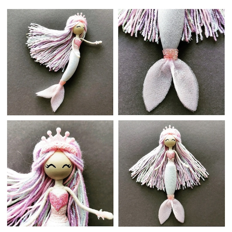 May include: A handmade mermaid doll with a pink and white yarn hair, a pink bodice, and a white tulle tail. The doll is wearing a crown and has a painted face.