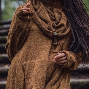 May include: A brown, long-sleeved sweater with a cowl neck and a mushroom-shaped pendant necklace.