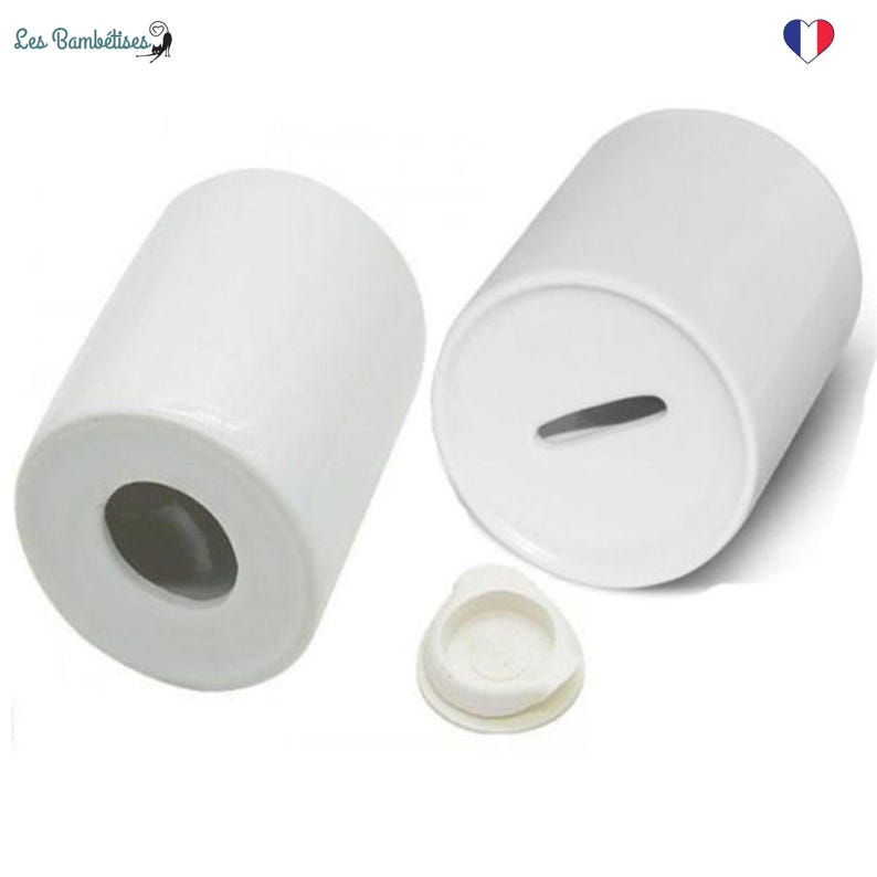 May include: Two white ceramic money boxes with a slot on the top and a removable lid. The money boxes are cylindrical in shape.