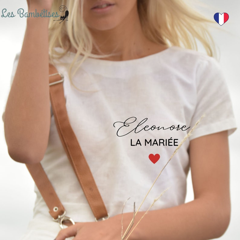 May include: White t-shirt with the text "Eleonore LA MARI&Eacute;E" and a red heart.