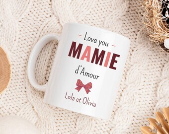 May include: White ceramic mug with a pink and brown bow and the text "Love you Mamie d'Amour Lola et Olivia" printed on it.