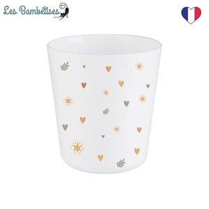 Puede incluir: Taza de cer&aacute;mica blanca con un patr&oacute;n de peque&ntilde;os corazones, estrellas y hojas en tonos marrones, naranjas y amarillos.