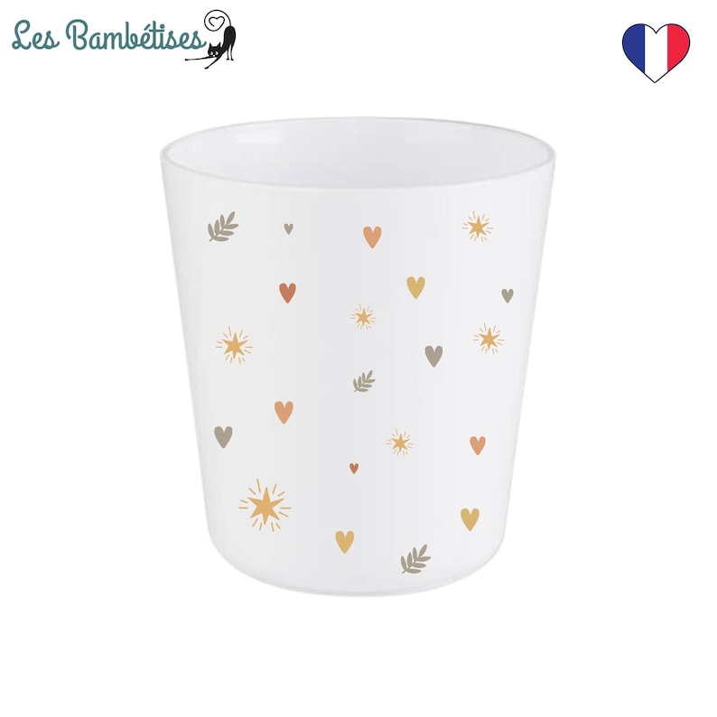 Puede incluir: Taza de cer&aacute;mica blanca con un patr&oacute;n de peque&ntilde;os corazones, estrellas y hojas en tonos marrones, naranjas y amarillos.