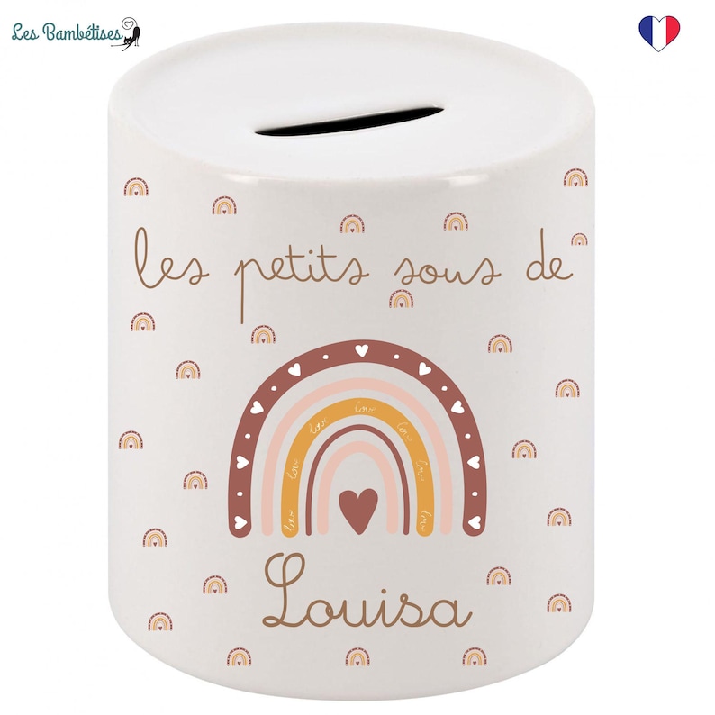 May include: White ceramic money box with a rainbow design and the text "les petits sous de Louisa".