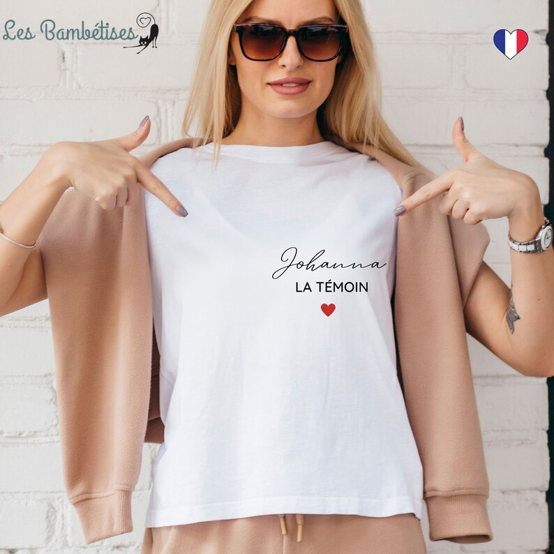 May include: White t-shirt with the text "Johanna LA T&Ecirc;MOIN" in black script with a red heart below.