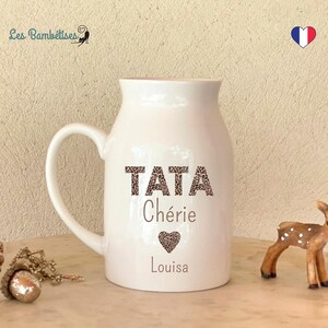 Op de afbeelding: Witte keramische mok met een bruin en zwart luipaardprintontwerp met de tekst "TATA Chérie Louisa" met een hart.