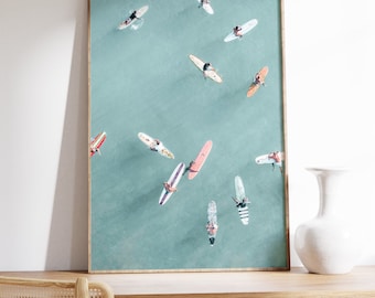 May include: A framed photograph of an aerial view of surfers on turquoise water. The surfers are on longboards and are spread out across the water.