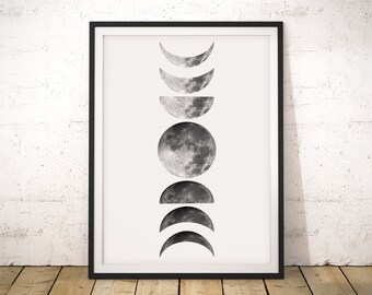 May include: A black and white print of the moon in various phases. The print is framed in a black frame and has the text "Yin + Yang Prints" at the bottom.