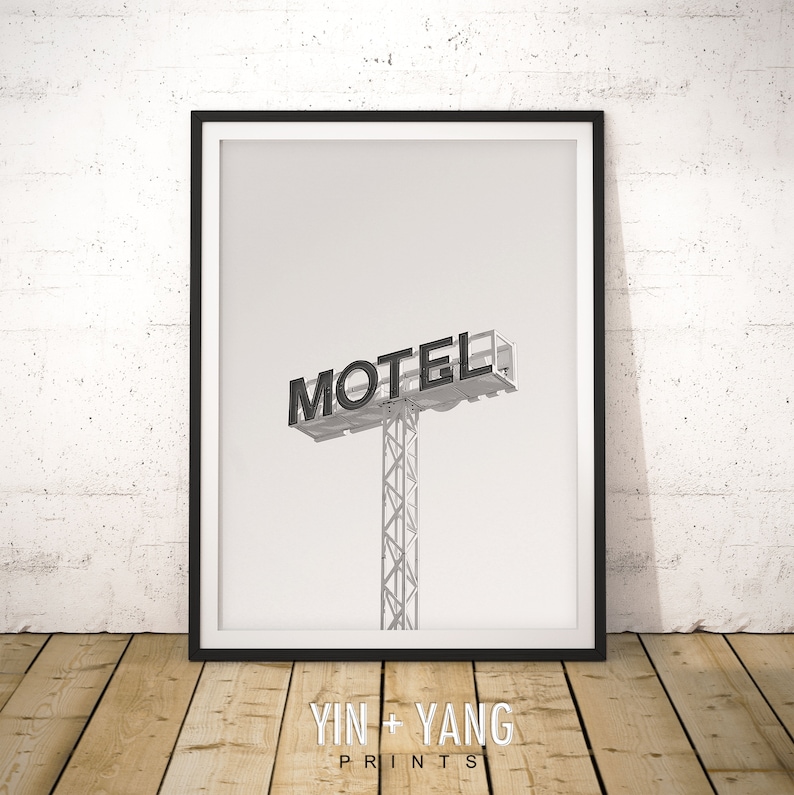 May include: Black and white photograph of a motel sign with the word "MOTEL" in bold letters. The sign is mounted on a tall metal pole.