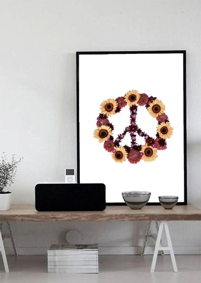 May include: A framed print of a peace sign made of sunflowers and purple flowers on a white background.