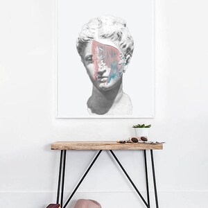 May include: A white plaster bust of a person with a pink and blue abstract paint design covering part of the face. The bust is on a white background.