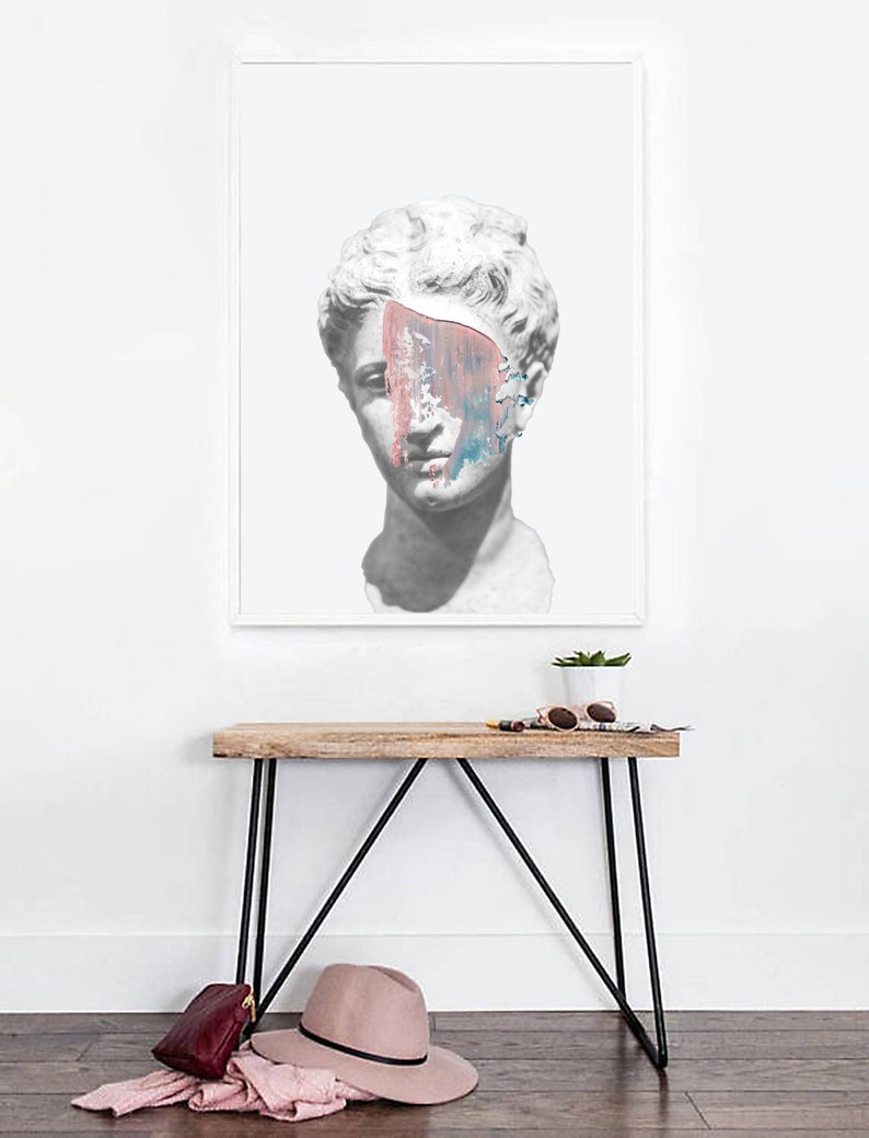 May include: A white plaster bust of a person with a pink and blue abstract paint design covering part of the face. The bust is on a white background.
