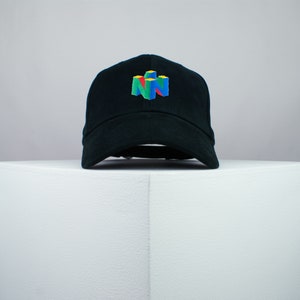 May include: A black baseball cap with a colorful Nintendo 64 logo embroidered on the front.