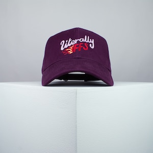 Puede incluir: Una gorra de béisbol de color morado con el texto "literally FFS" bordado en rosa, rojo y amarillo.
