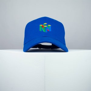 May include: A royal blue baseball cap with a colorful Nintendo 64 logo embroidered on the front.