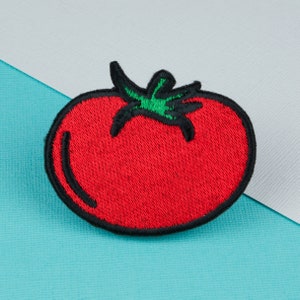 May include: Red embroidered tomato patch with a green stem and black outline.