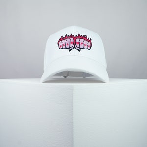 May include: White baseball cap with a red and pink embroidered design of two fists on fire.