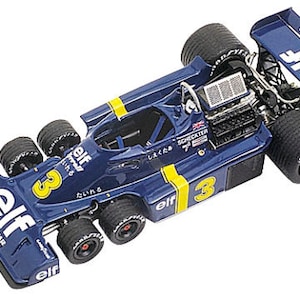 Könnte beinhalten: Detailliertes Modell eines blau-gelben Formel-1-Rennwagens. Das Auto hat die Nummer 3, das Elf-Logo und Goodyear-Reifen. Der Heckflügel zeigt die Logos von Elf und Goodyear. Das Modell hat sechs Räder.