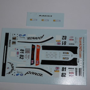 Peut inclure: Feuille de décalcomanie pour une voiture de course Panoz Esperante, avec le numéro de la voiture 81 et 82, le nom de l'équipe "Team LNT.com" et les logos de divers sponsors. La feuille est imprimée sur du papier blanc avec des accents bleus.