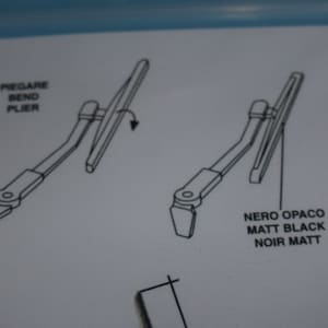 May include: Diagram showing how to bend a wiper arm using pliers. The text reads "Pre-gare Bend Plier" and "Nero Opaco Matt Black Noir Matt".