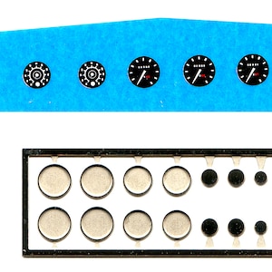 Peut inclure: Une feuille de décalcomanies noires et blanches pour un tableau de bord d'avion modèle. Les décalcomanies présentent divers jauges, cadrans et chiffres. Les décalcomanies sont disposées en rangées sur un fond bleu.