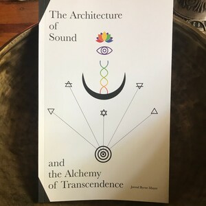 Puede incluir: Un libro blanco con el t&iacute;tulo "The Architecture of Sound and the Alchemy of Transcendence" de Jarrod Byrne Mayer. La portada presenta una luna creciente negra con una espiral de arco&iacute;ris en su interior, una flor de loto, un ojo y s&iacute;mbolos geom&eacute;tricos.