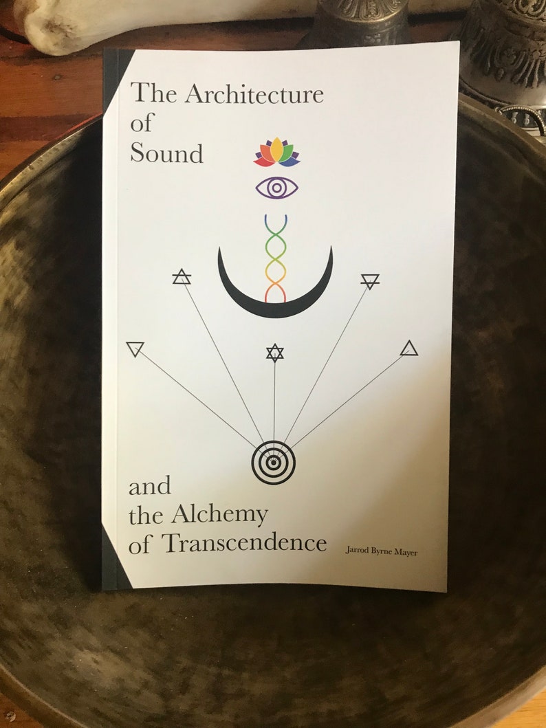 Puede incluir: Un libro blanco con el t&iacute;tulo "The Architecture of Sound and the Alchemy of Transcendence" de Jarrod Byrne Mayer. La portada presenta una luna creciente negra con una espiral de arco&iacute;ris en su interior, una flor de loto, un ojo y s&iacute;mbolos geom&eacute;tricos.