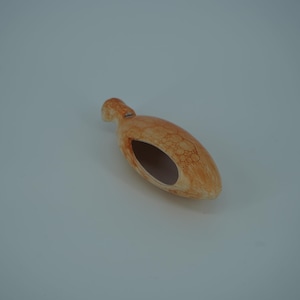 May include: A small, ceramic, orange-brown, bird-shaped, hanging planter with a hole in the bottom for drainage.