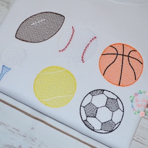 May include: Embroidered design of various sports balls, including a football, baseball, golf ball, tennis ball, basketball, and soccer ball. The design is stitched on a white fabric.