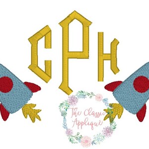 Op de afbeelding: Een monogram met de letters CPH in goud, omringd door twee blauwe en rode raketten met gele vlammen.