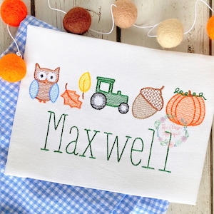 May include: Embroidered design featuring an owl, a leaf, a tractor, an acorn, and a pumpkin. The name Maxwell is embroidered below the design.