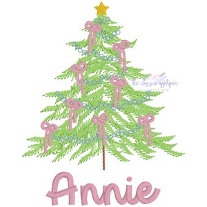 May include: A green Christmas tree decorated with pink bows and blue garland. The name "Annie" is written in pink cursive below the tree.