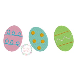 Puede incluir: Tres huevos de Pascua con diferentes diseños. Uno es rosa con líneas azules onduladas, otro es azul claro con puntos amarillos y el último es verde con una línea blanca en zigzag y una línea marrón.