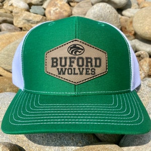 May include: Green and white trucker hat with a brown leather patch that says "Buford Wolves" with a wolf head logo.