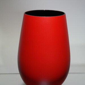 May include: A vibrant red vase with a black interior. The vase has a rounded, teardrop shape and a smooth, matte finish. The design is simple and modern, suitable for home decor.