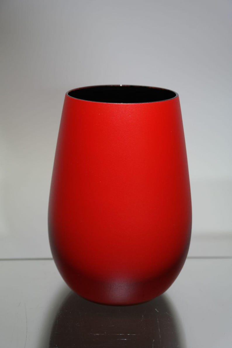 May include: A vibrant red vase with a black interior. The vase has a rounded, teardrop shape and a smooth, matte finish. The design is simple and modern, suitable for home decor.