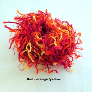 Peut inclure: Un &eacute;cheveau de fil rouge, orange et jaune avec une texture duveteuse.