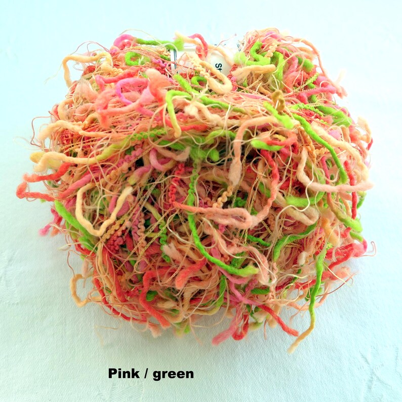 Peut inclure: Une pelote de fil rose et vert avec une texture longue, fine et vaporeuse. Le fil est parfait pour cr&eacute;er des projets uniques et d&eacute;licats.