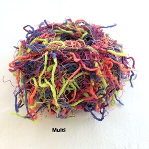 Peut inclure: Un &eacute;cheveau de fil color&eacute; dans des tons de violet, vert, orange et rouge. Le fil est compos&eacute; d'un m&eacute;lange de fibres et a une texture duveteuse. Le fil est &eacute;tiquet&eacute; "Multi".