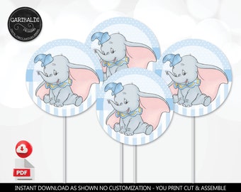 May include: Blue and pink printable party circles featuring a cartoon illustration of Dumbo the elephant. The circles have a blue and white striped pattern.