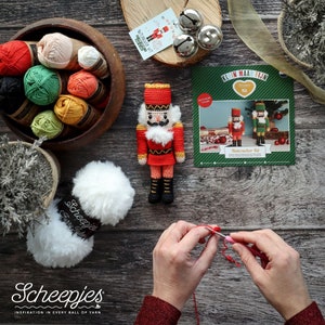 Può includere: Una bambola schiaccianoci all'uncinetto, una ciotola di legno piena di vari gomitoli di lana colorati, un gomitolo di lana bianca Scheepjes Furry Tales, tre campanellini argentati e un libretto di istruzioni Klein Maar Fijn Nutcracker Kit.
