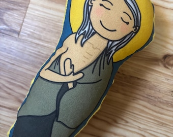 以下が含まれることがあります： 手作りの布製人形、エジプトのマリアを描いています。人形は「St. Mary of Egypt」の文字が入った黄色の光輪、笑顔の顔、長い白髪が特徴です。人形の服はオリーブグリーンと黒です。
