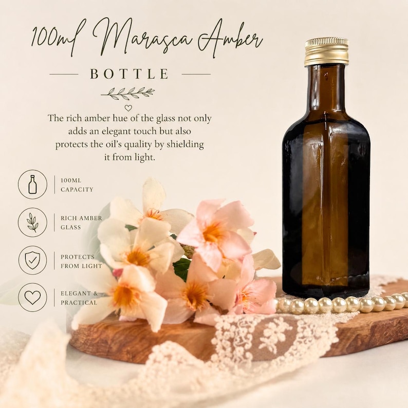 May include: A 100ml Marasca Amber bottle with a gold cap. The dark amber glass bottle is displayed with flowers and lace. Text on the image reads "100ml Marasca Amber Bottle". The bottle protects the oil's quality by shielding it from light.
