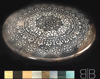 May include: Round wooden table top with a white lace design. The table top is dark brown and has a glossy finish.